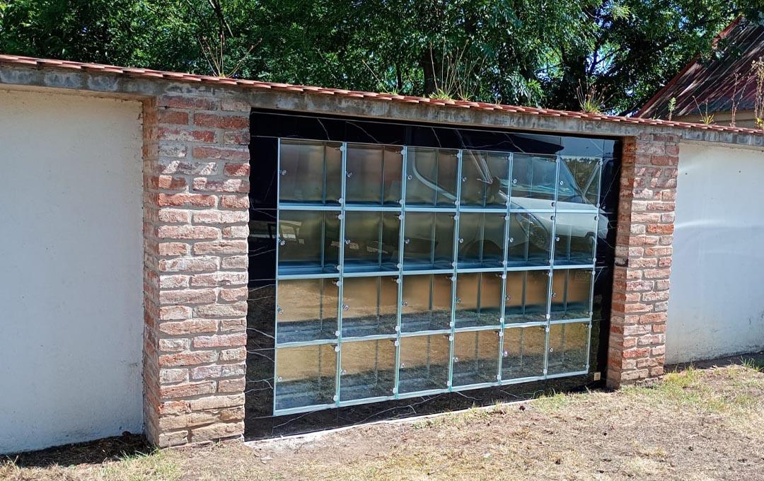 Moderné kolumbáriá s mramorovým obkladom a čiernym rámovaním, obklopené upravenou zeleňou, lavičkami a chodníkmi v upravených priestoroch cintorínov – ukážka riešení od spoločnosti MODU-AL.