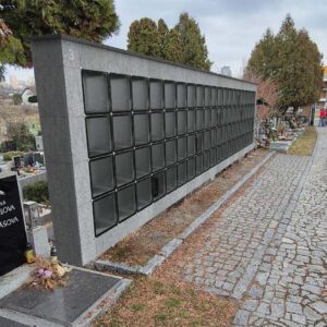 Moderné kolumbáriá s mramorovým obkladom a čiernym rámovaním, obklopené upravenou zeleňou, lavičkami a chodníkmi v upravených priestoroch cintorínov – ukážka riešení od spoločnosti MODU-AL.